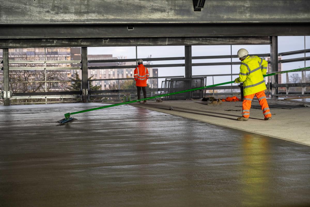 Construction workers prepare the ground surface