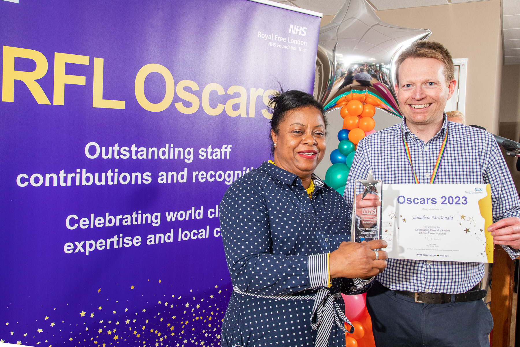 Janadean posing with her certificate and award alongside David Bray