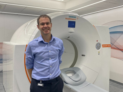 Thomas Wagner beside the QUADRA PET scanner at the Royal Free Hopspital